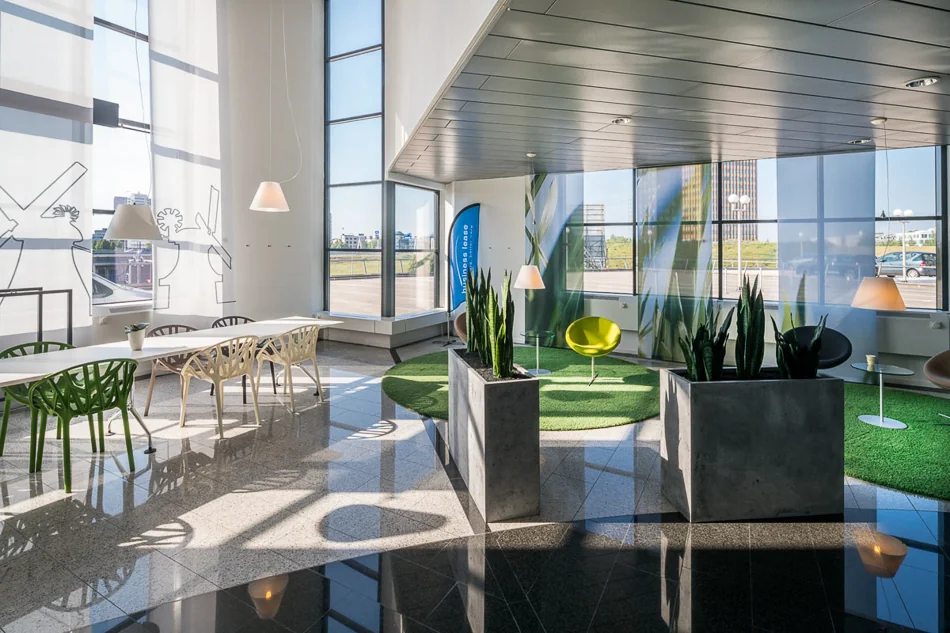 Moderne en lichte wachtruimte in het Rivium Quadrant met designstoelen, plantenbakken en grote ramen met uitzicht.